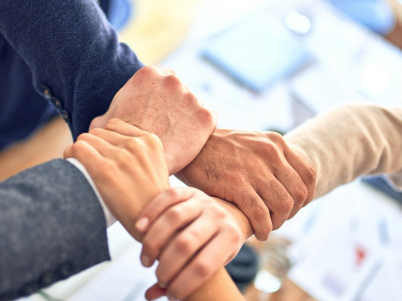 Business team joining hands together in partnership